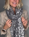 Woman wearing an animal print scarf and beige coat 