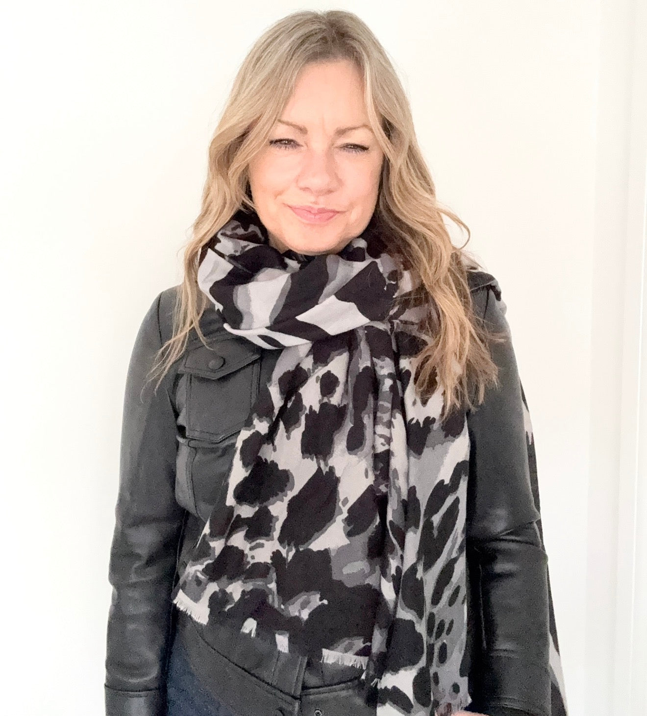 Woman wearing a black and white animal print patterned scarf 