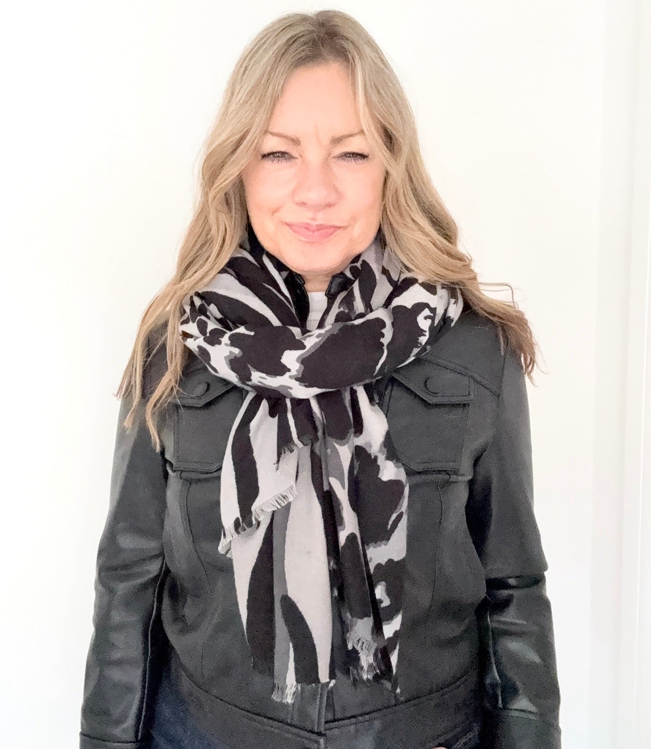 Woman wearing a black and white animal print patterned scarf 