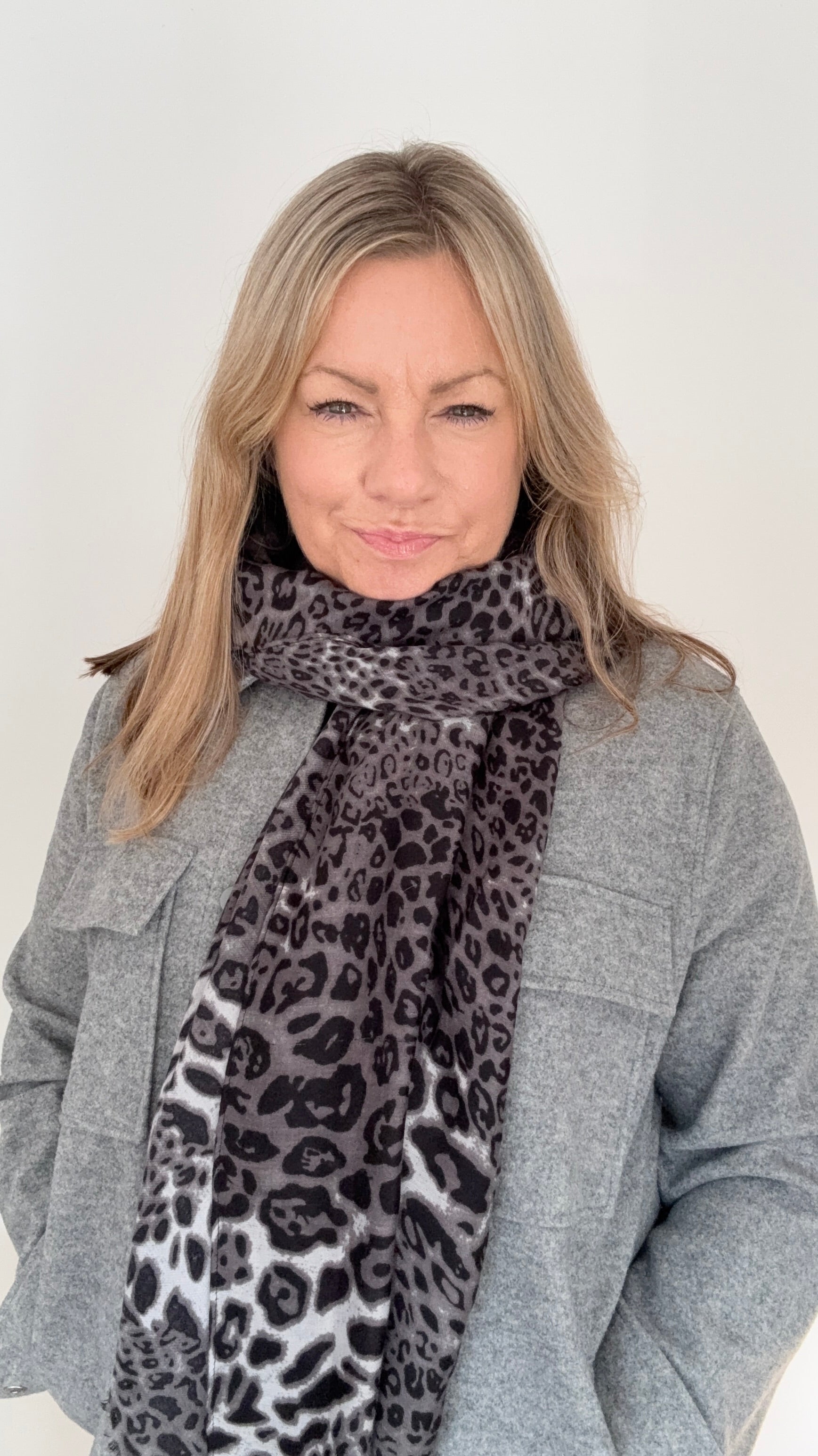 Woman wearing a midweight grey mix leopard print scarf for autumn winter