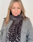 Woman wearing a midweight grey mix leopard print scarf for autumn winter
