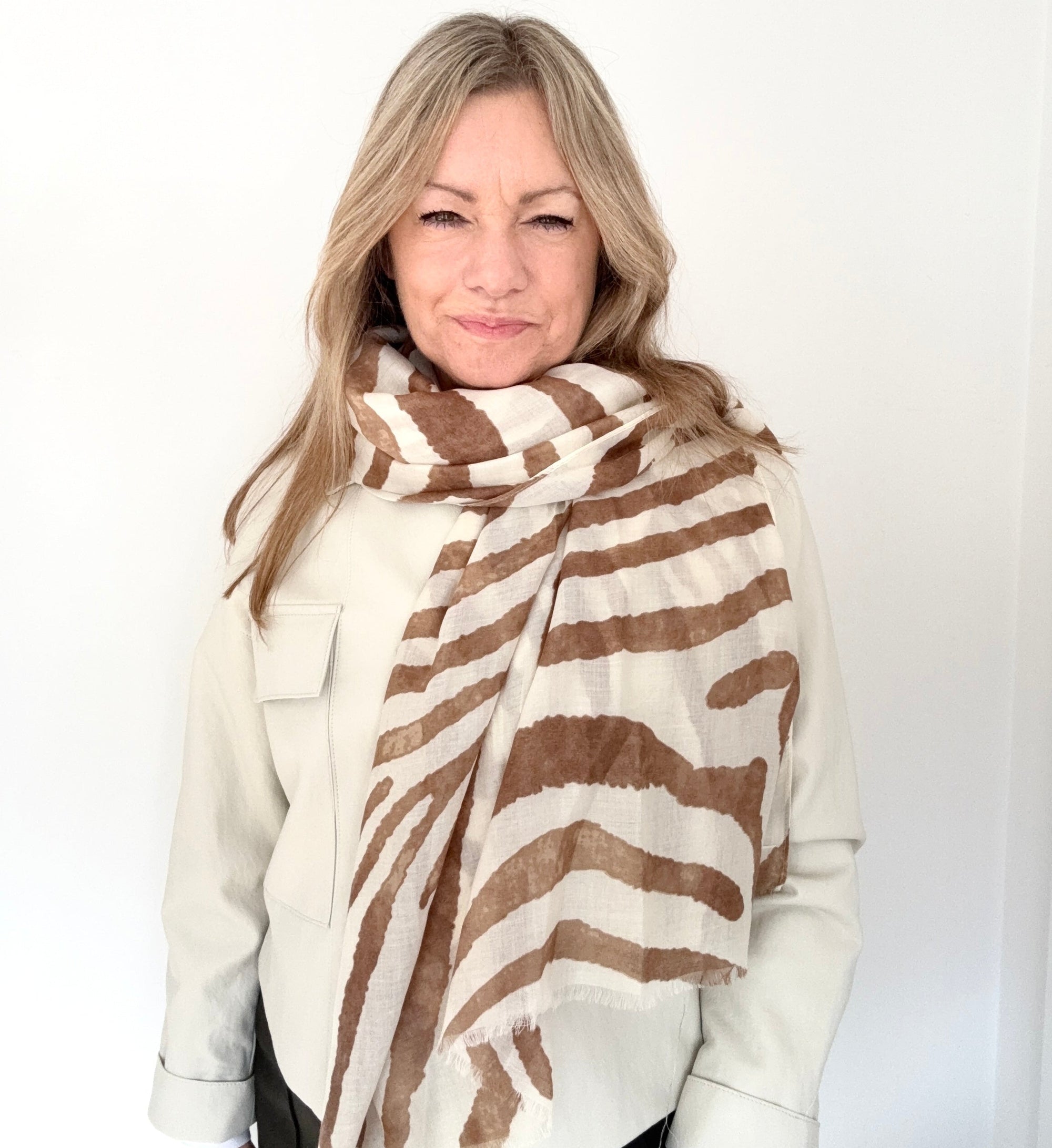Woman wearing a brown and cream zebra print lightweight scarf