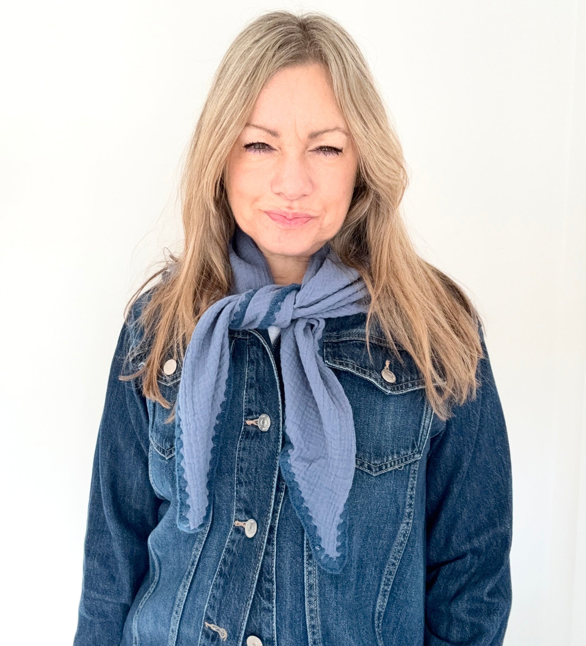 Woman wearing a denim jacket and blue cotton triangle scarf 