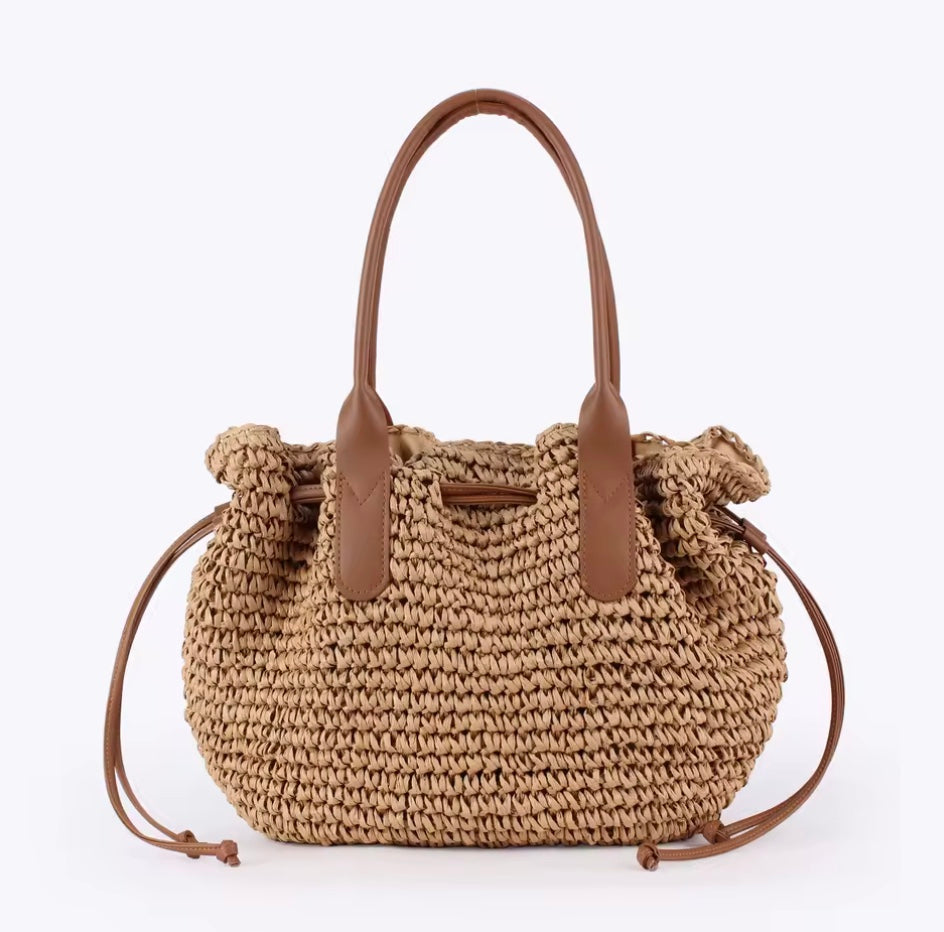 Woven handbag with brown handles on a white background