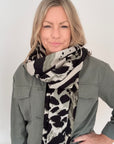 Woman wearing a khaki animal print midweight patterned scarf and khaki jacket for aurumn winter