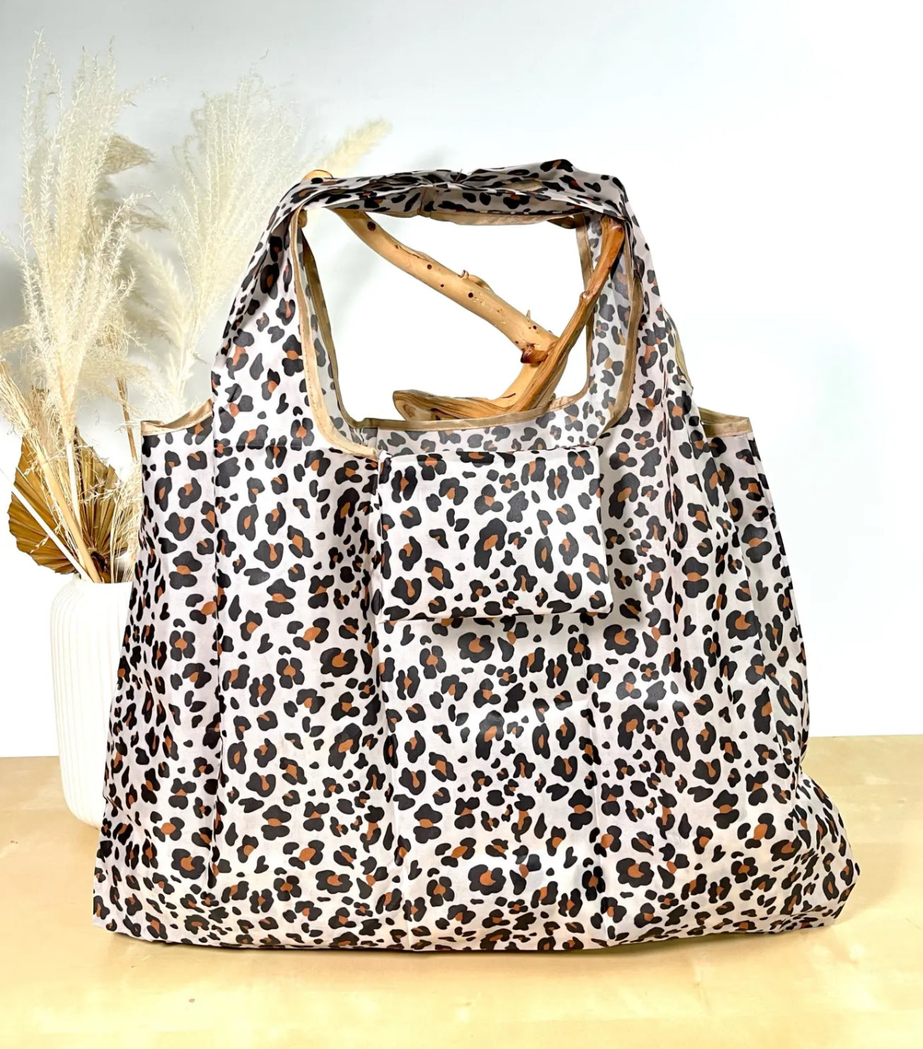 Leopard print bag with  handles on a light background