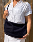 woman holding a navy bag 