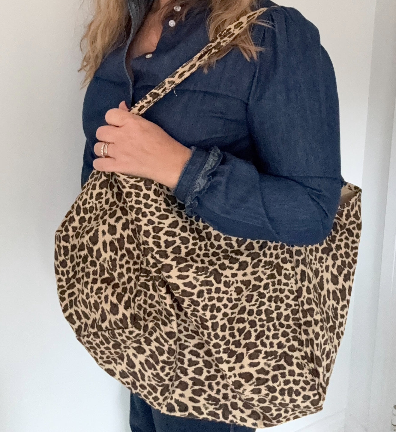 woman holding a leopard print tote bag 