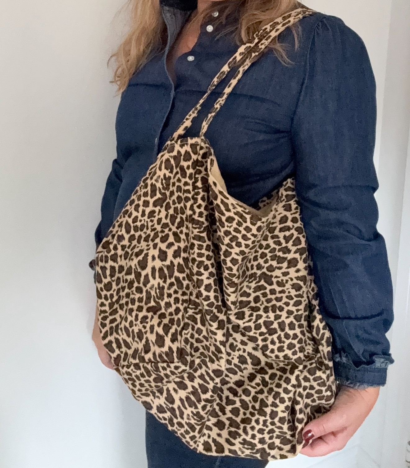 woman holding a leopard print tote bag 