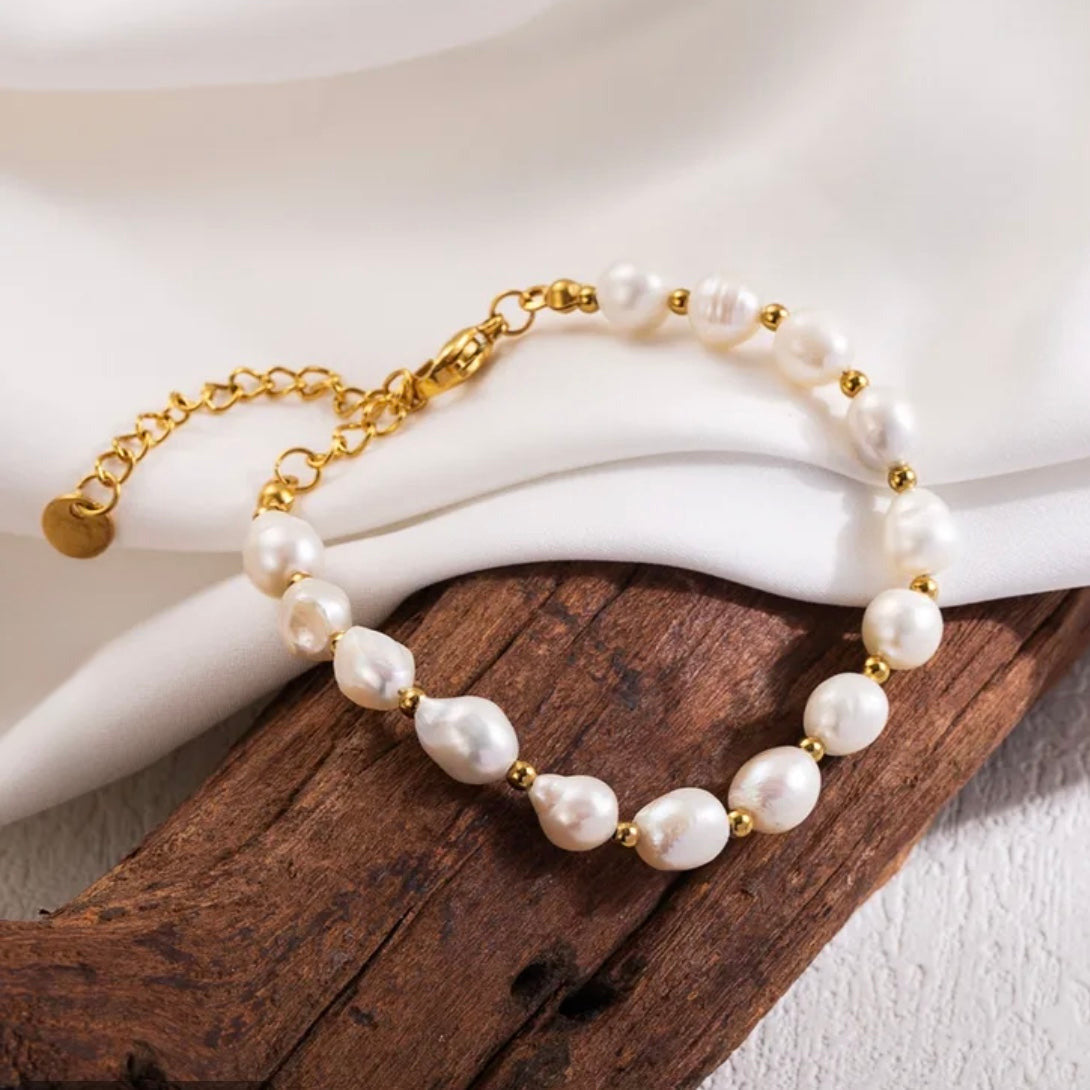 Pearl bracelet with gold accents on a wooden surface