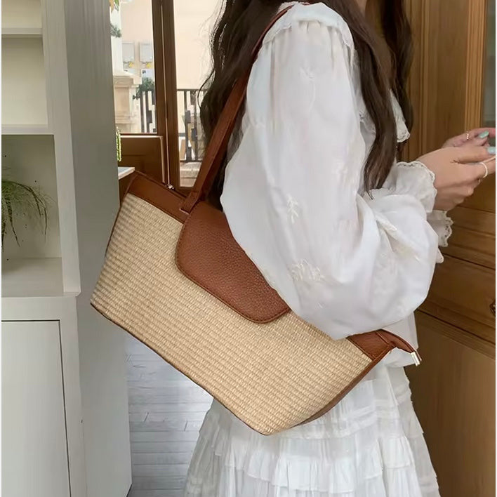 woman wearing a white dress holding a straw and dark tan summer handbag on her shoulder