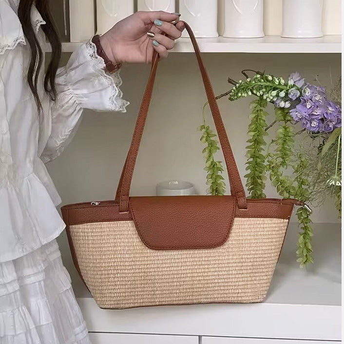Person holding a brown and tan shoulder summer handbag with a white background and decorative elements.
