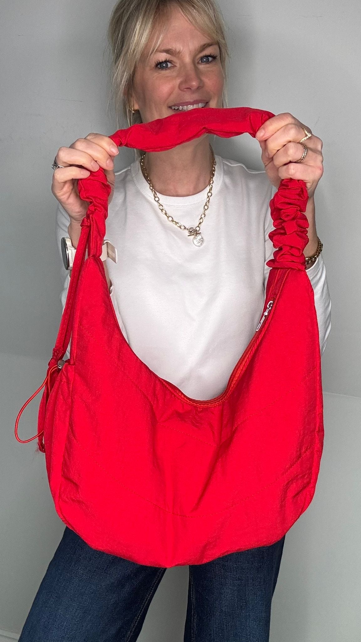 woman holding a red fabric crossbody bag 
