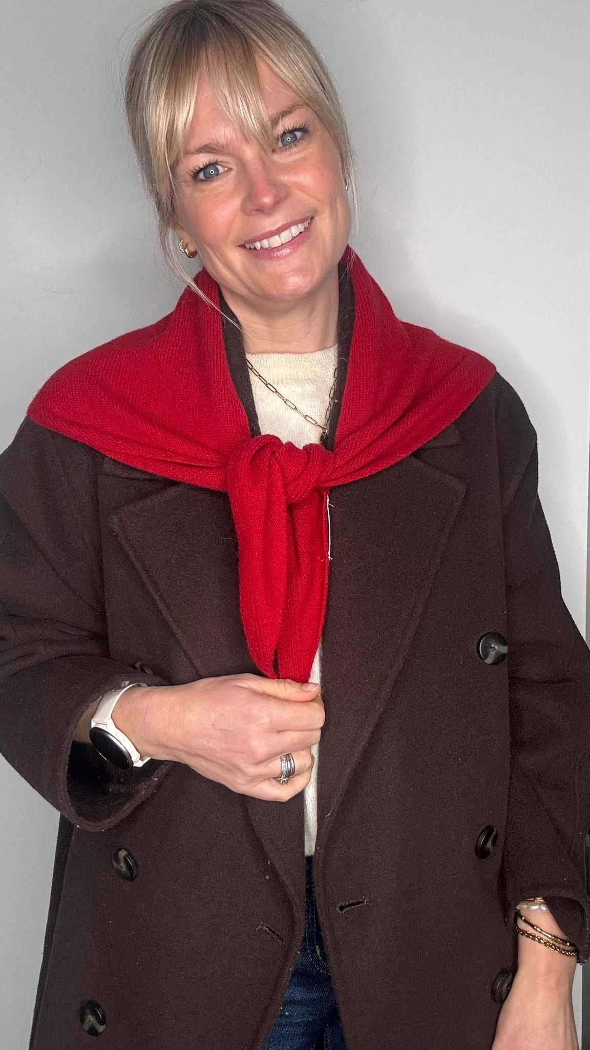woman wearing a brown jacket and a red wool scarf