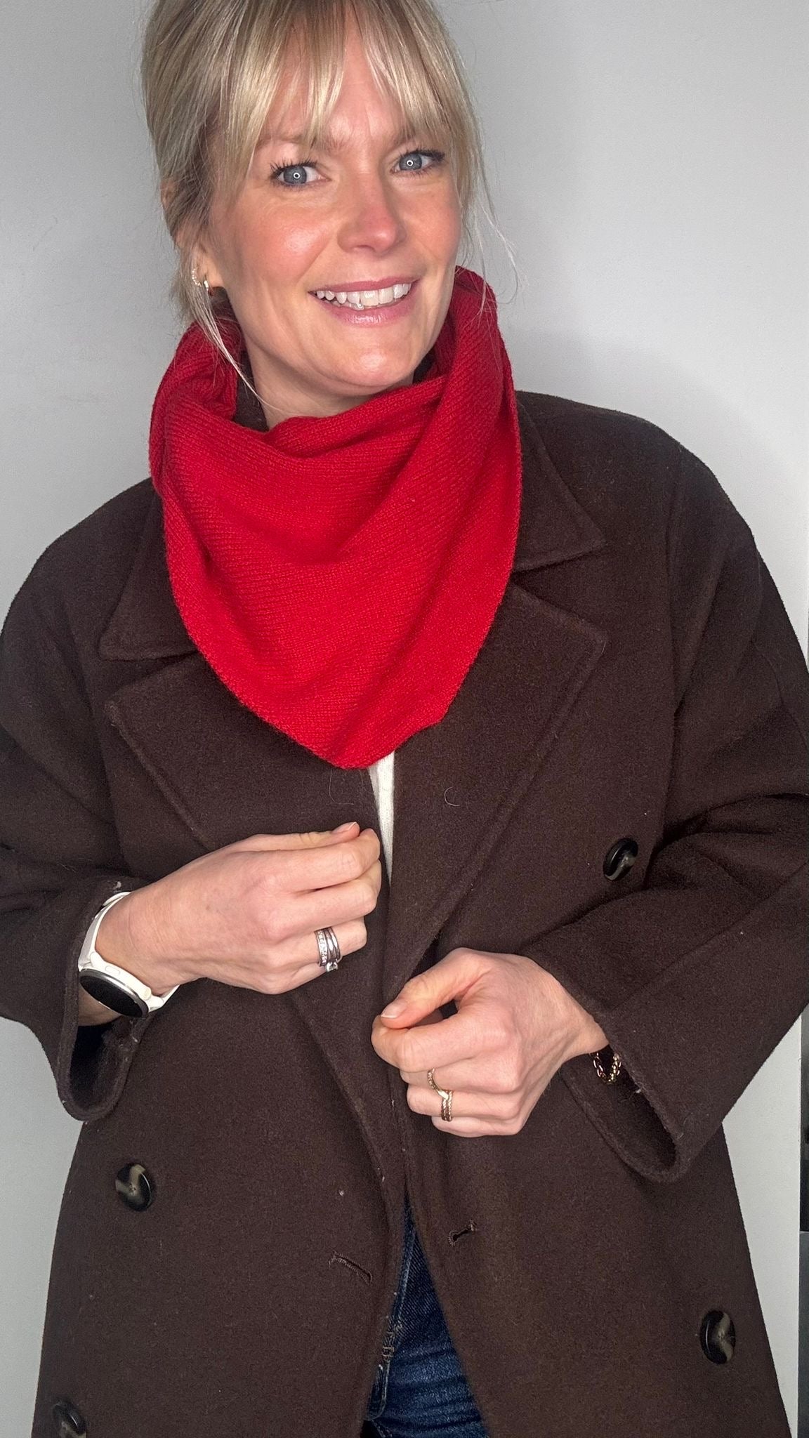woman wearing a brown jacket and a red wool scarf