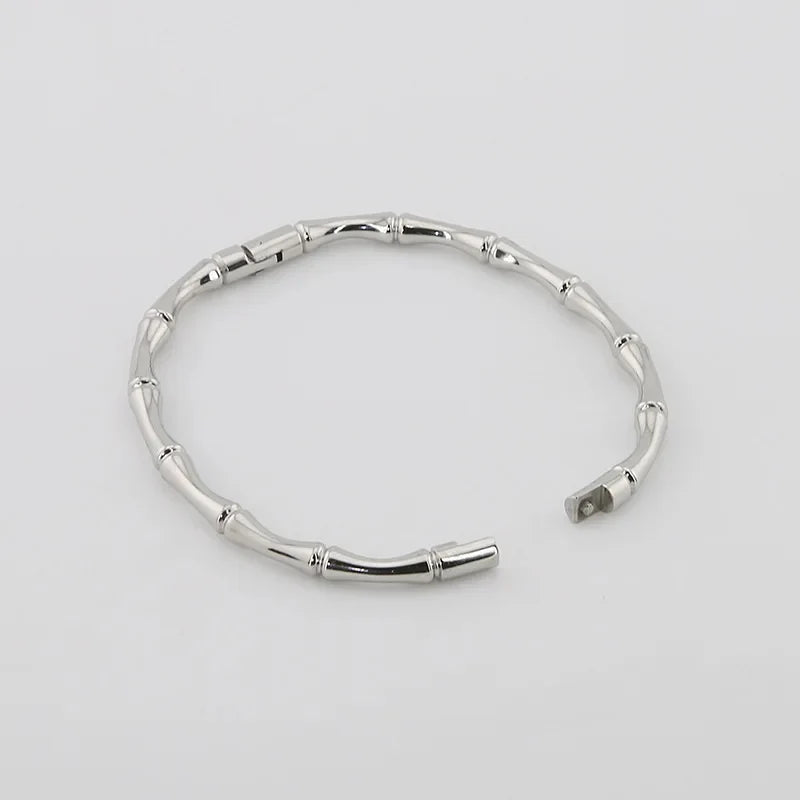 A silver bamboo bangle bracelet with a hinged opening,