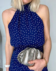 A woman holding a silver clutch-style Silver Cloud Bag with a chain link crossbody strap.

