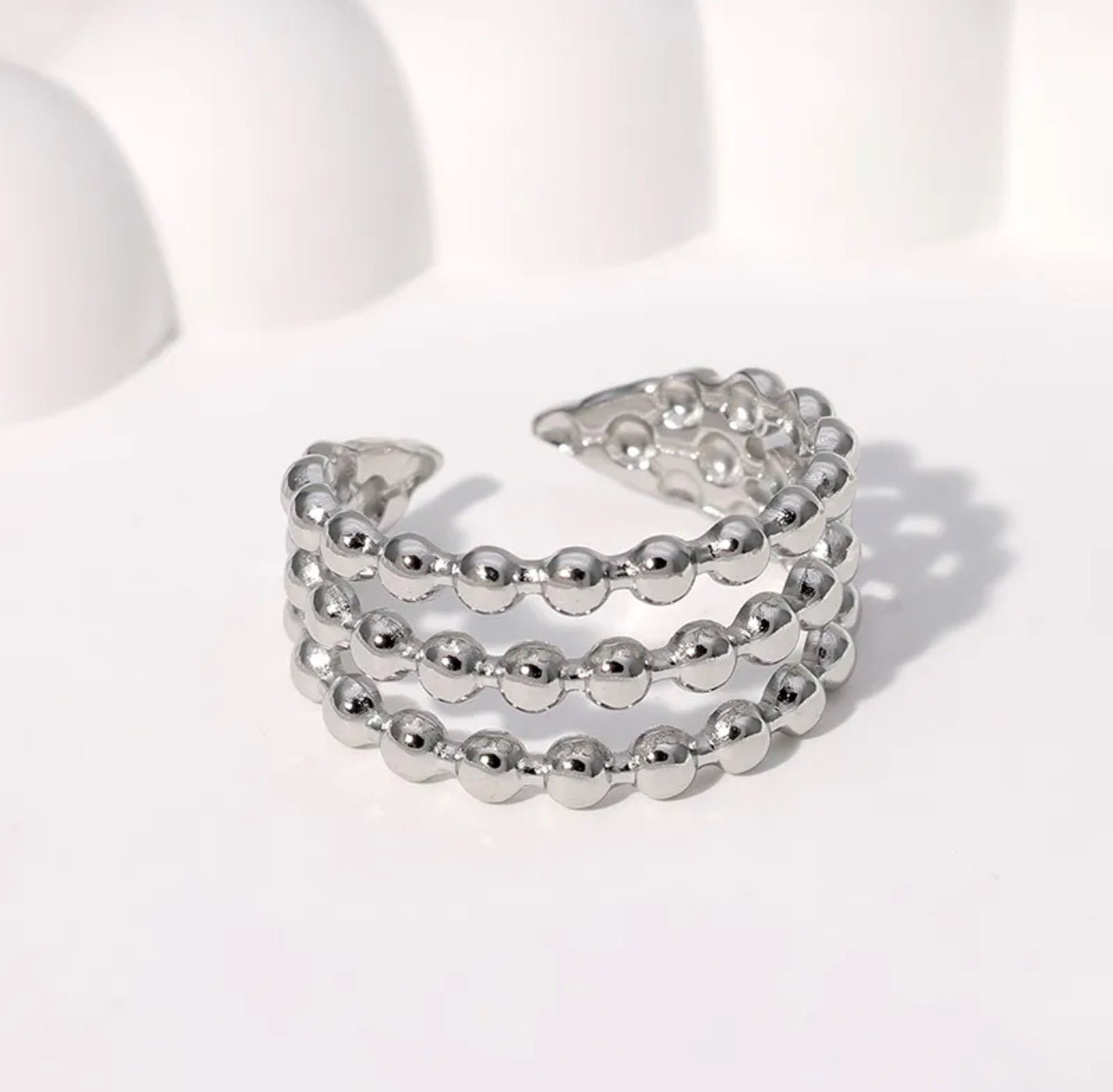 Stack of silver beaded rings on a light background