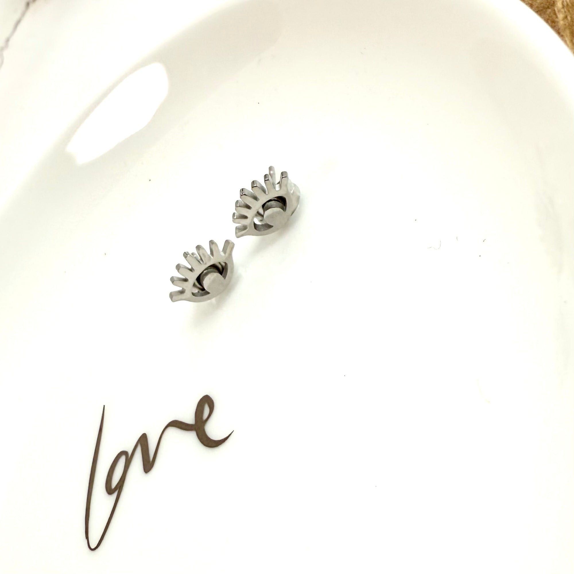 Pair of silver earrings on a white surface 