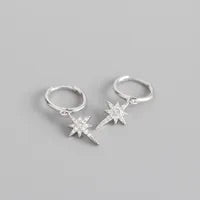 A pair of silver hoop huggies with silver sparkly star charms on a grey background.