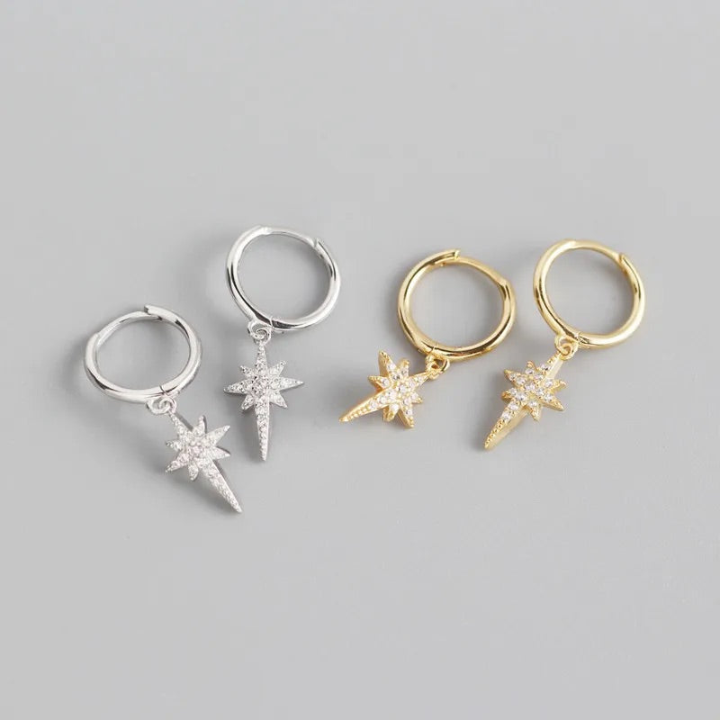 two pairs of silver and gold sparkly star hoop earrings. 