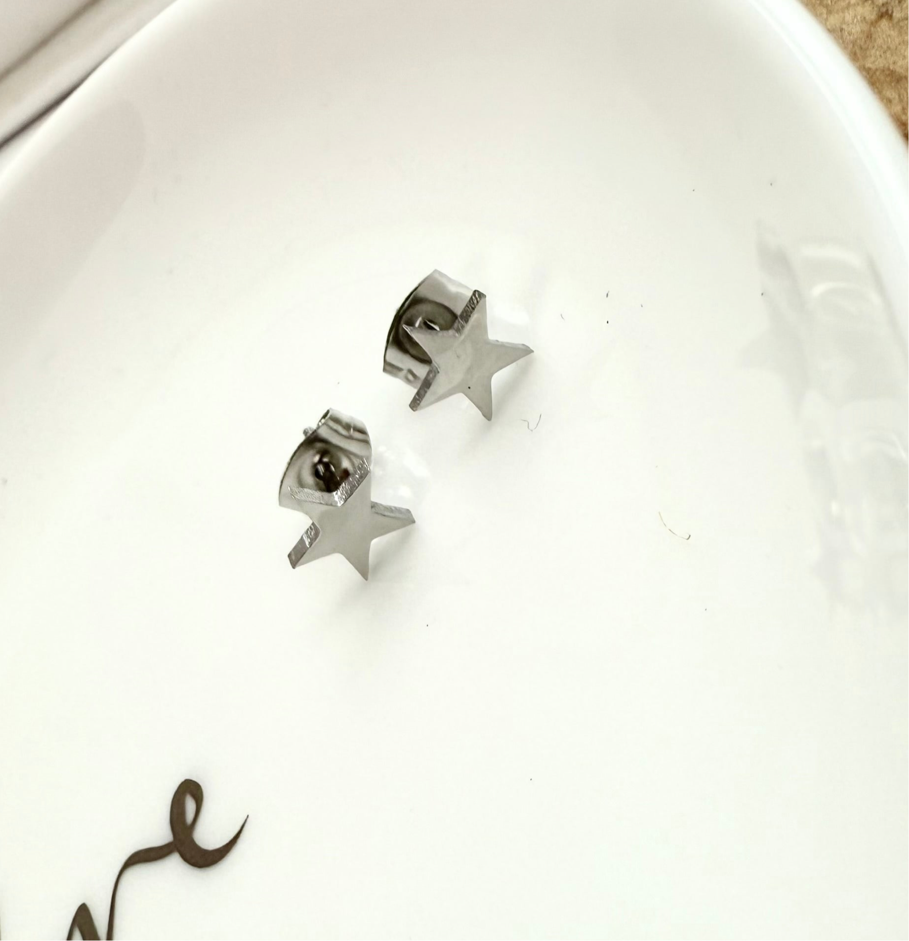 Star-shaped silver earrings on a white surface