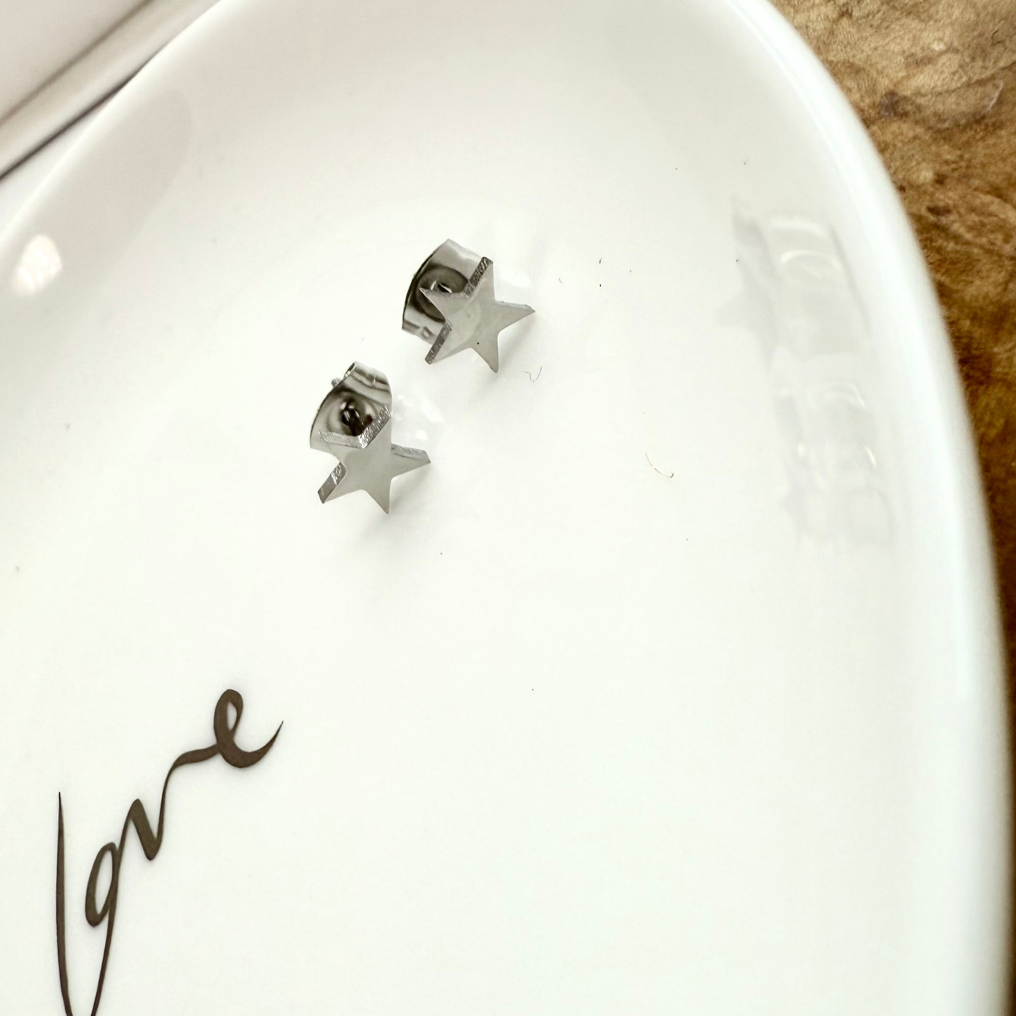 Star-shaped earrings on a white dish 