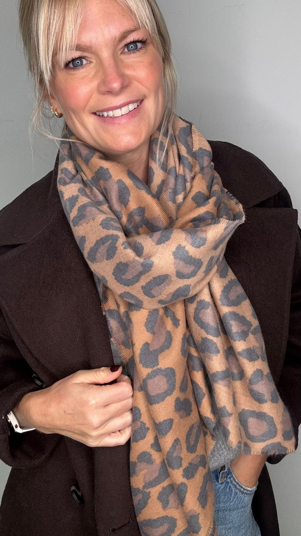 Woman wearing a brown suede coat and a mixed animal print scarf 