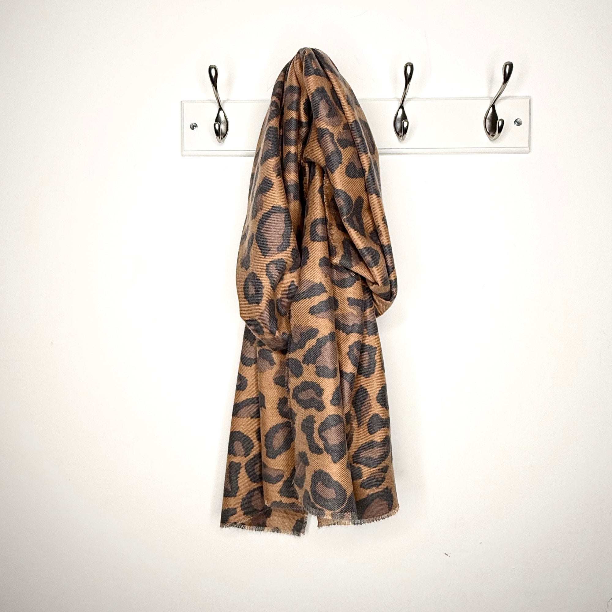  mixed animal print scarf draped over a peg on a white wall