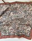 Animal print square scarf with brown border on a white background.