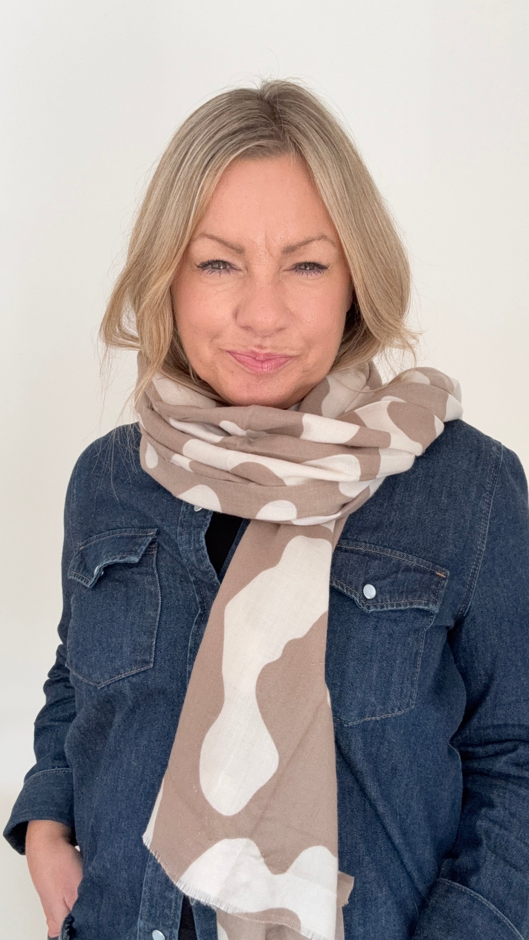 Woman wearing a taupe & ecru animal print scarf for Autumn Winter