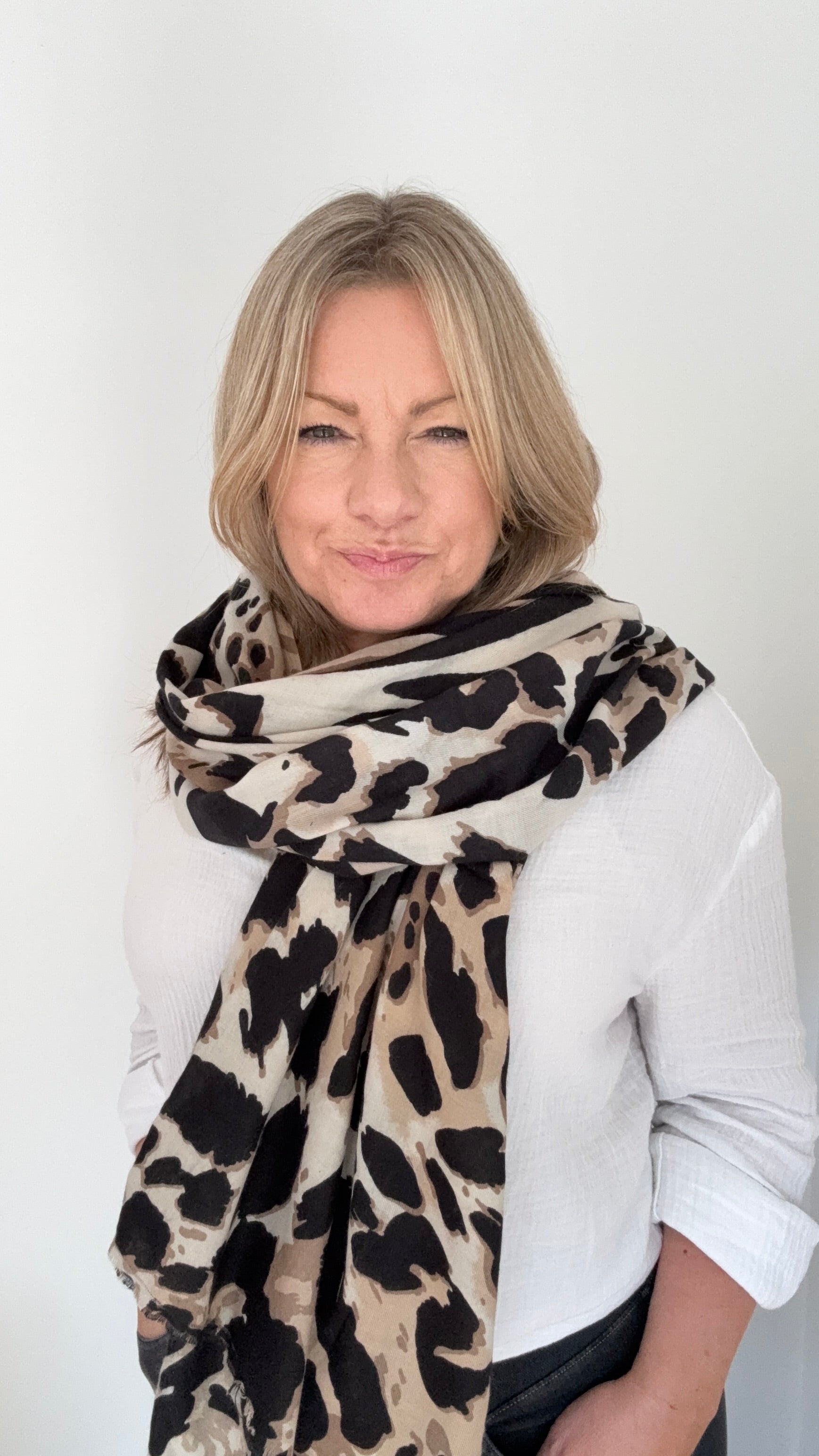 Woman wearing a taupe animal print scarf for autumn winter