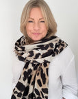 Woman wearing a taupe animal print scarf for autumn winter