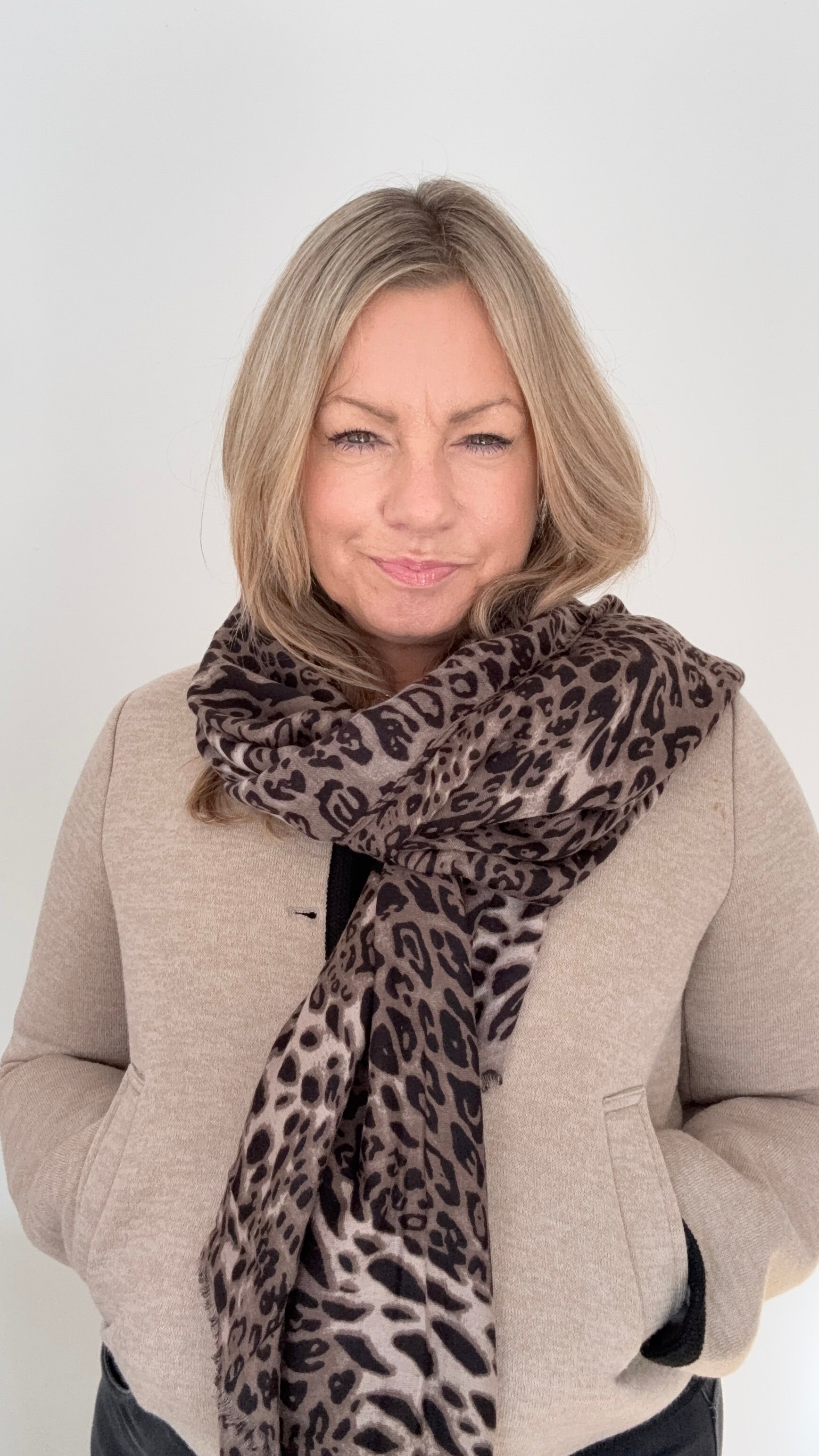Woman wearing a midweight taupe mix leopard print scarf for autum,n winter layering