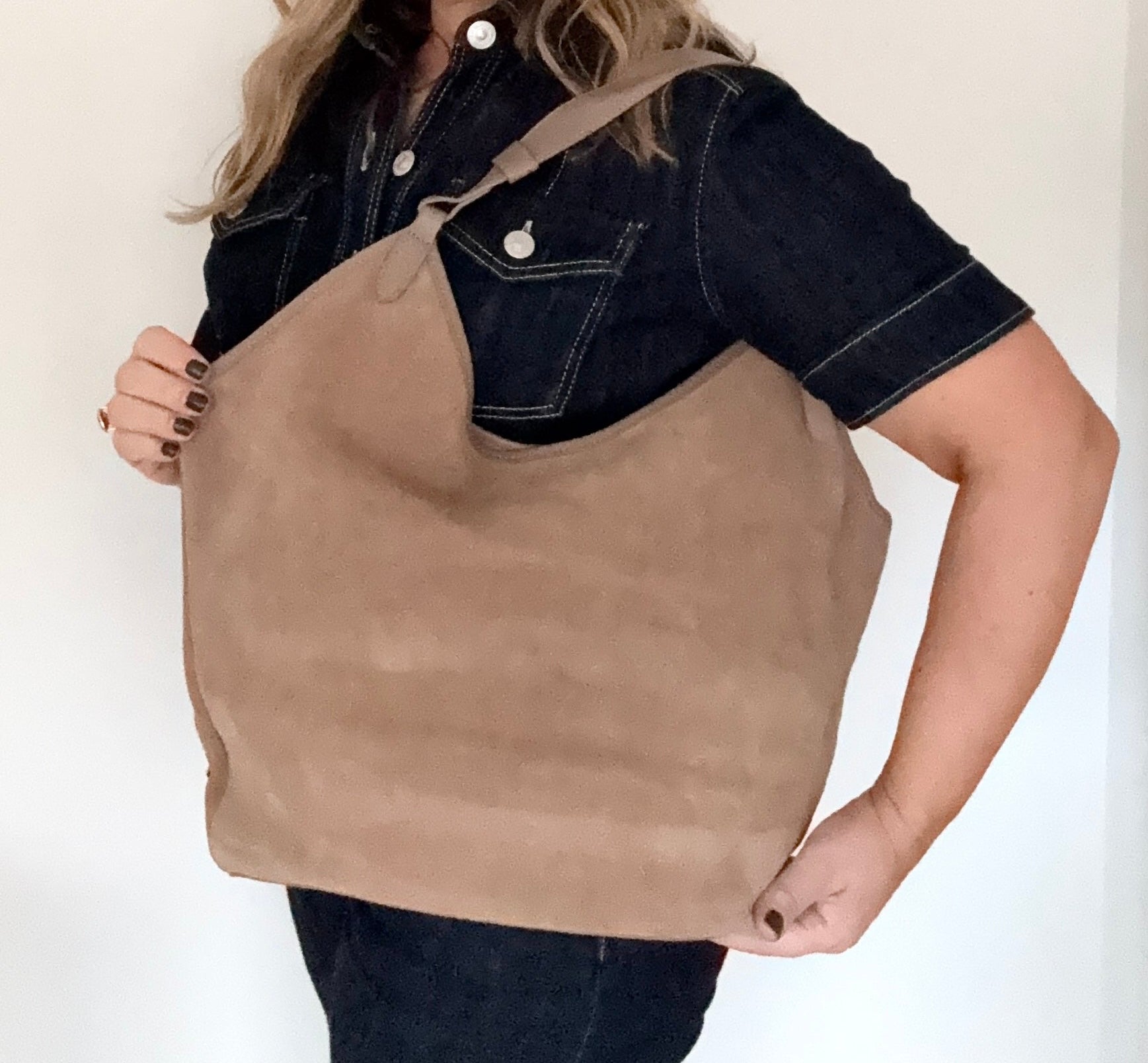 woman holding a large taupe suede tote / shoulder bag 